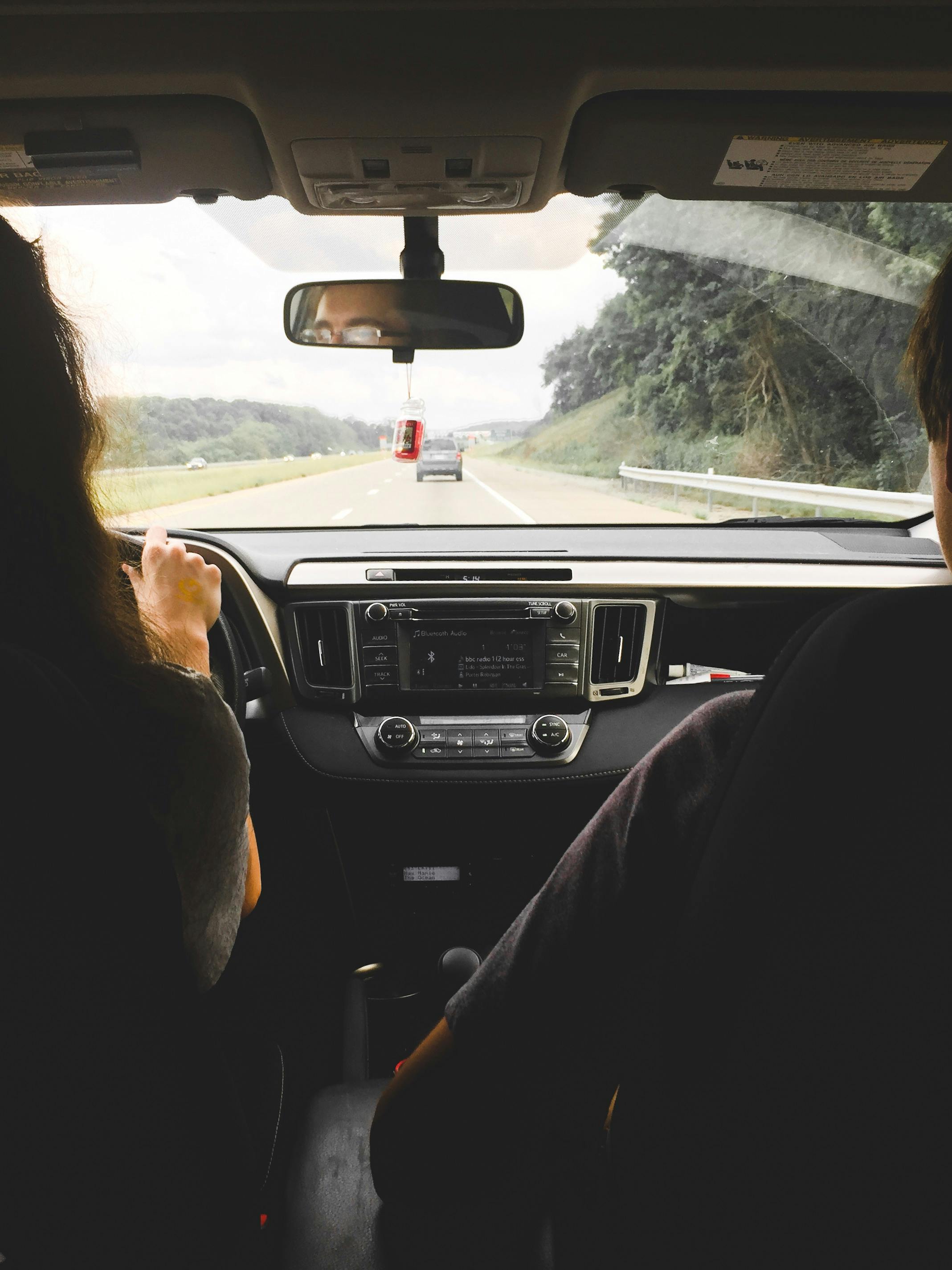 Two people sitting in car looking outward